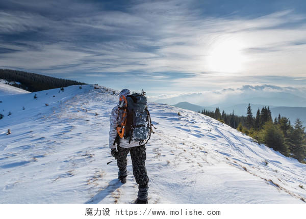 人背着背包在冬天雪山